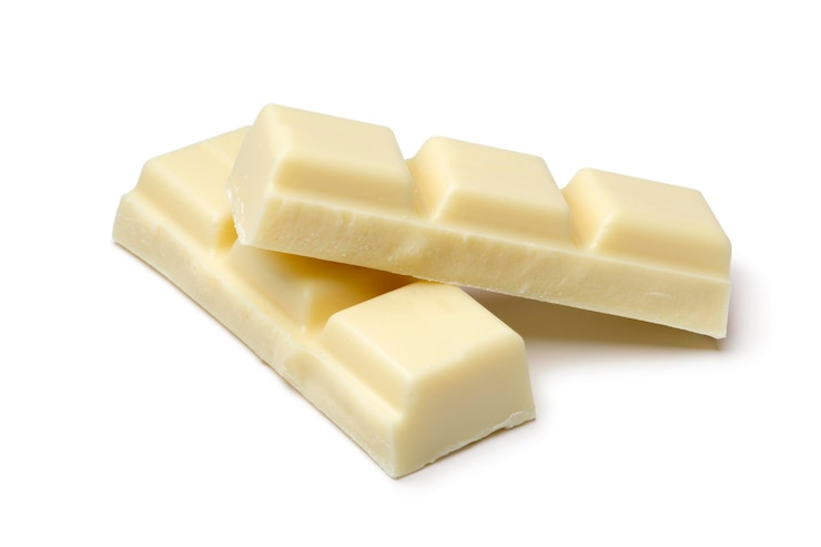 Foto trozos de chocolate blanco aislado sobre fondo blanco de cerca