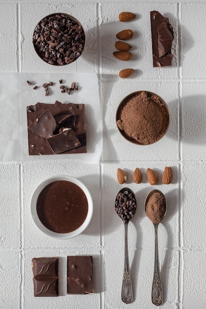 Trozos de chocolate chocolate caliente chispas de chocolate y nueces sobre un fondo blanco.