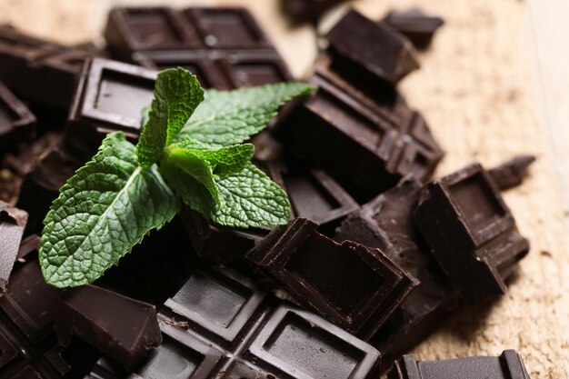 Trozos de chocolate y menta sobre fondo de madera