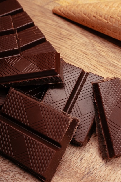 Trozos de chocolate negro y con leche en una mesa de madera