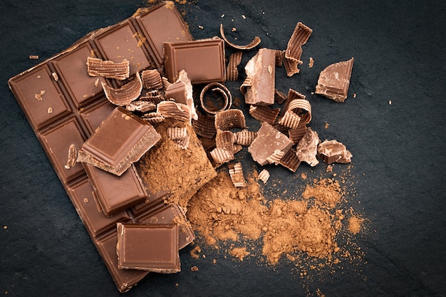 Trozos de chocolate rotos y cacao en polvo