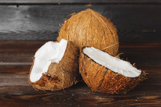 Trozos de coco agrietados sobre fondo de madera oscura