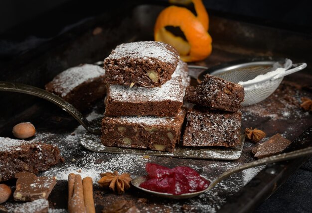 Trozos cuadrados horneados de brownie de chocolate espolvoreados con azúcar en polvo sobre la mesa