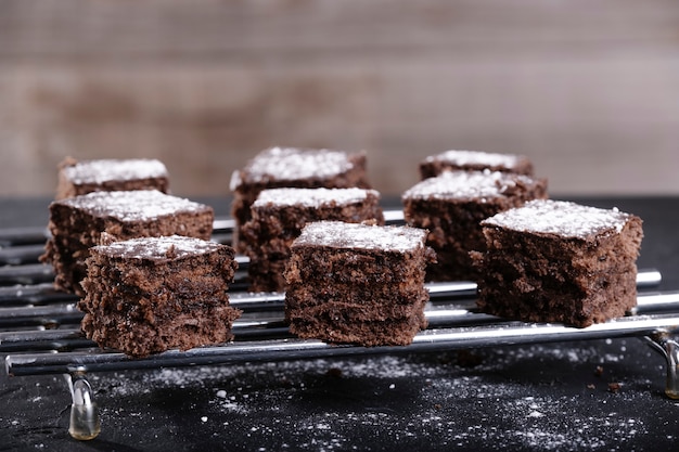 Trozos cuadrados de pastel de chocolate y azúcar en una rejilla de acero