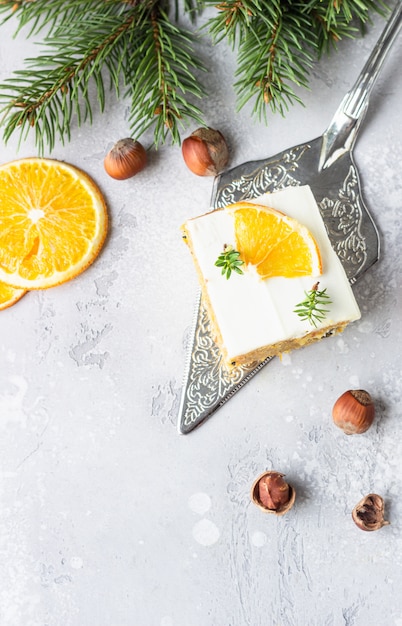 Trozos cuadrados de pastel de zanahoria cruda especiada con glaseado de naranja, nueces y queso crema.