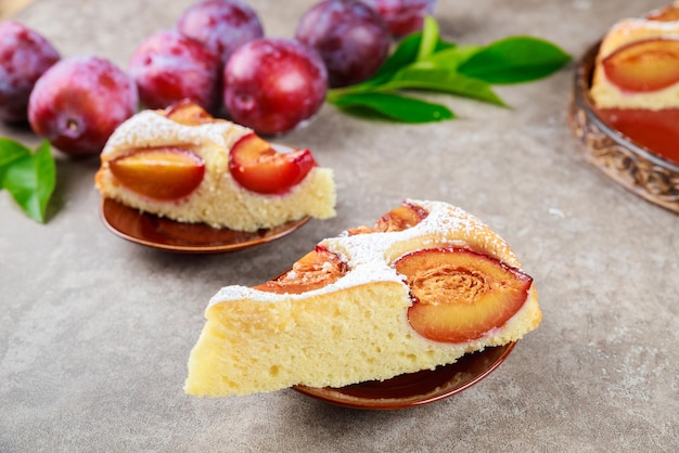 Trozos de delicioso pastel de ciruelas rojas cubiertas con azúcar en polvo.