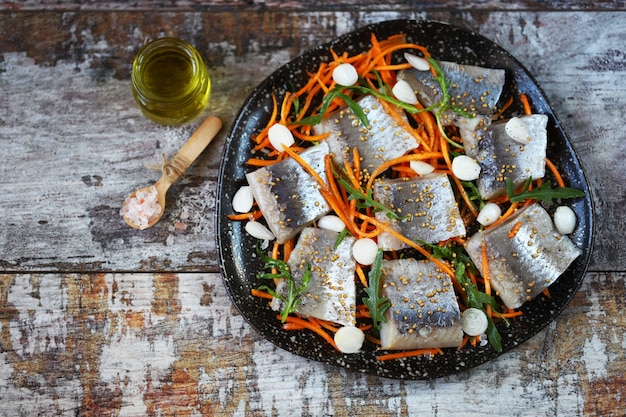 Trozos de filete de arenque marinados con especias en un plato