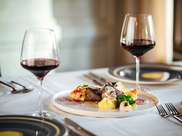 Trozos de filetes de carne de vacuno con diferentes salsas y vino tinto