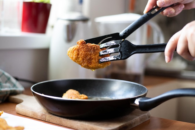 Trozos fritos de pollo empanizado Preparación de una cena tradicional