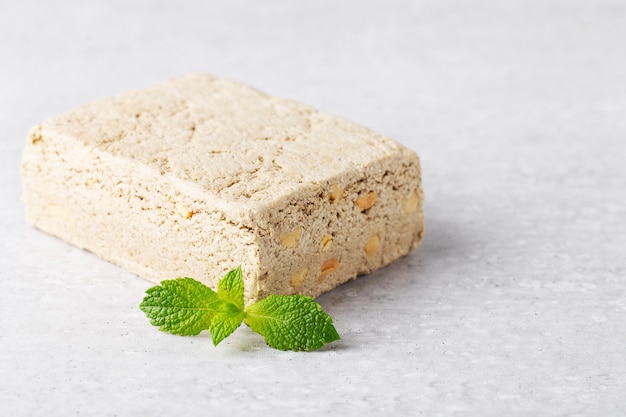 Trozos de halva de girasol con cacahuetes menta fondo gris claro