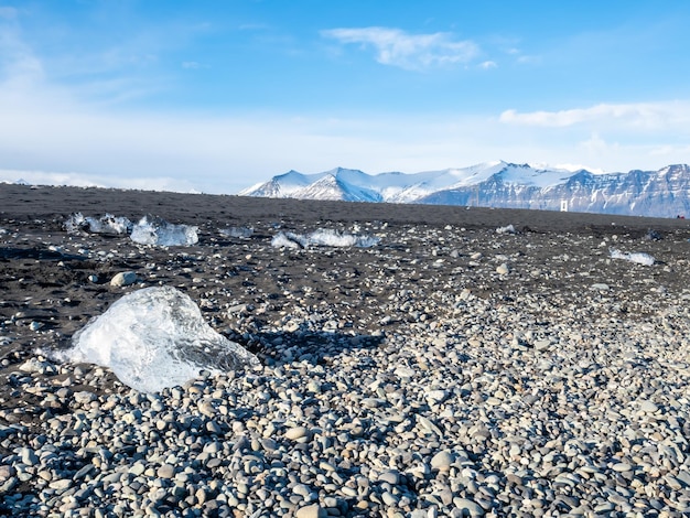 Trozos de hielo brillan como diamantes en una playa de arena negra en invierno en Islandia