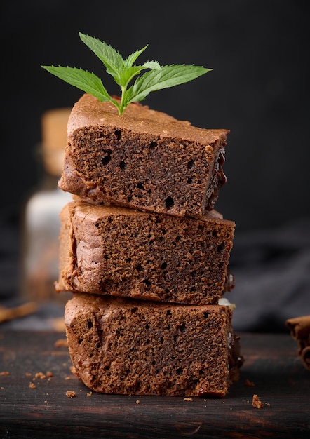 Trozos horneados de pastel de brownie de chocolate en un postre delicioso de mesa negra