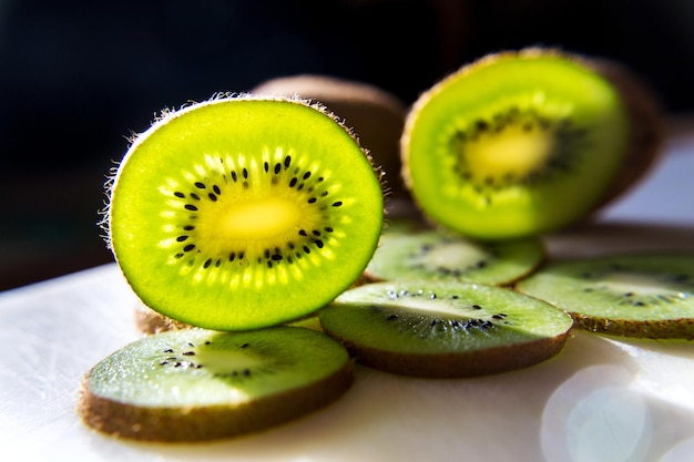 Trozos de kiwi fresco verde en rodajas iluminadas sobre la mesa dieta saludable concepto de resolución de año nuevo