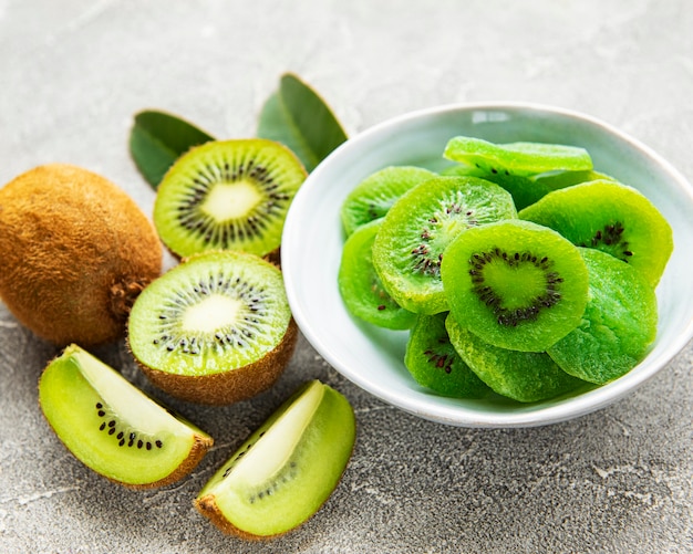 Trozos de kiwi seco en un recipiente sobre una superficie de hormigón gris