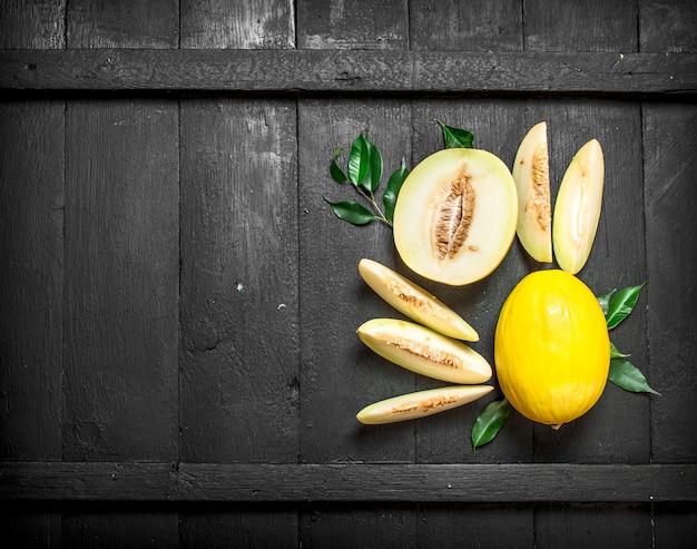 Trozos maduros de melón. Sobre un fondo de madera negra.