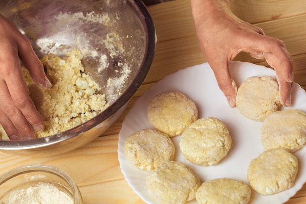 Trozos de masa en las manos del cocinero.