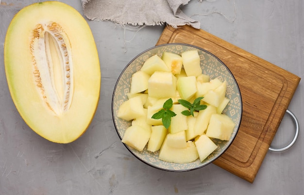 Trozos de melón en rodajas en un plato gris redondo sobre la mesa