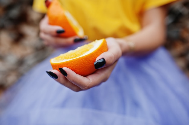 Trozos de naranja en manos de niña