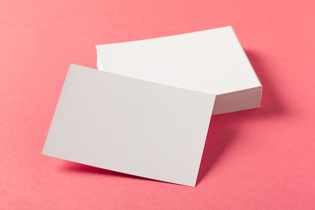 Foto trozos de papel en blanco sobre un fondo de color rosa