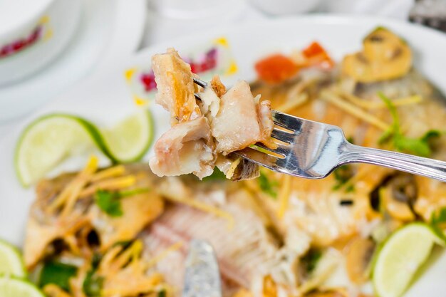 Trozos de pescado Pomfret en un tenedor closeup