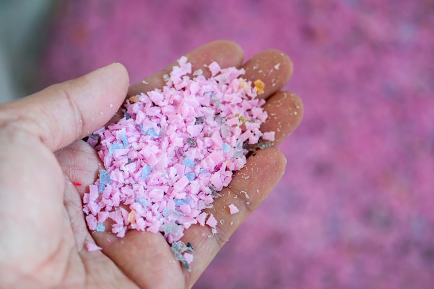 Trozos de plástico rosa claro en una mano