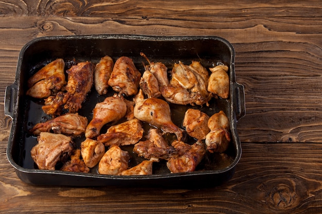 Trozos de pollo al horno en una bandeja para hornear