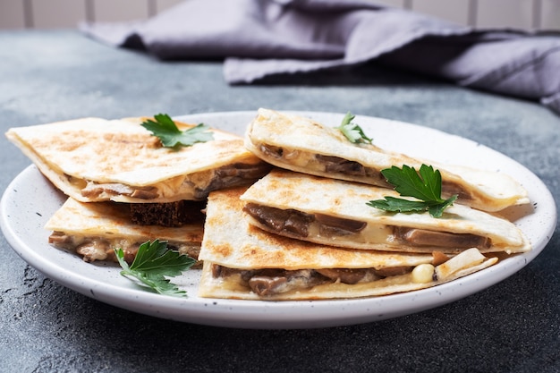 Trozos de quesadilla con crema agria de champiñones y queso