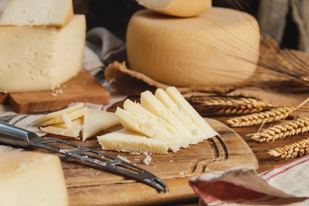 Trozos de queso casero fresco sobre una tabla de madera con un cuchillo