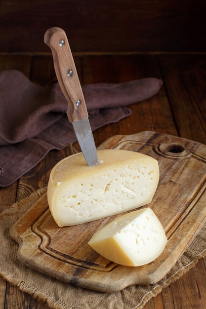 Trozos de queso italiano casero fresco sobre una tabla de madera de cerca