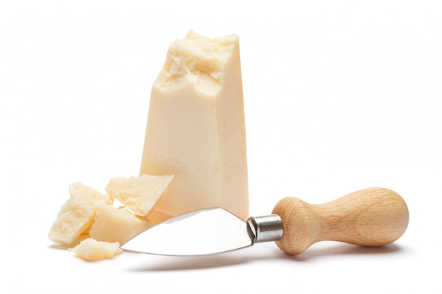 Trozos de queso parmesano y cuchillo en mesa blanca