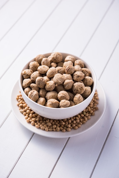 Trozos de soja cruda carne de soja para veganos aislado en la mesa de madera en un recipiente o en forma de montón