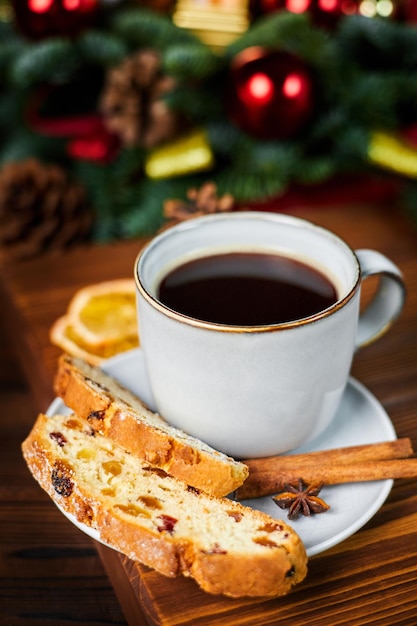 Trozos de stollen y una taza de café en el fondo de la decoración navideña