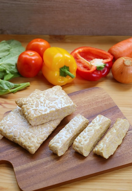 Trozos de tempeh fresco cortado para cocinar platos a base de plantas de alimentos integrales