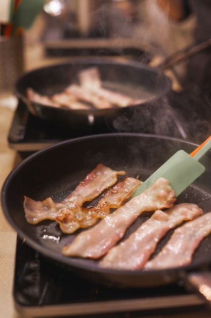 Trozos de tocino fritos en una sartén