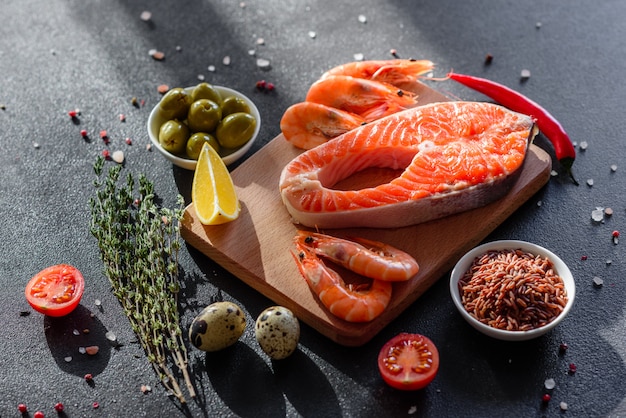 Trucha cruda filete de pescado rojo servido con hierbas y limón y aceite de oliva. Cocinar salmón. Concepto de alimentación saludable