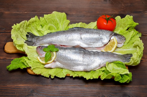 Trucha preparada con verduras sobre un fondo de madera