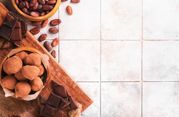 Trufas de chocolate con cacao en polvo en un plato de madera sobre un viejo fondo de mesa de azulejos agrietados Sabrosas trufas de chocolate dulces Concepto del Día de San Valentín y el Día de la Madre con espacio de copia Vista superior