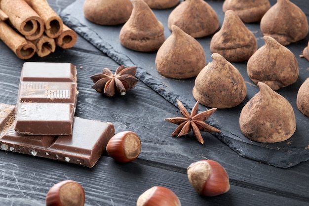 Trufas de chocolate caseras y chocolate surtido con nueces y otras especias en la mesa de la cocina antigua rústica.