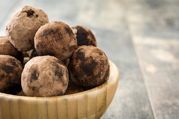 Trufas de chocolate caseras en un recipiente en la mesa de madera