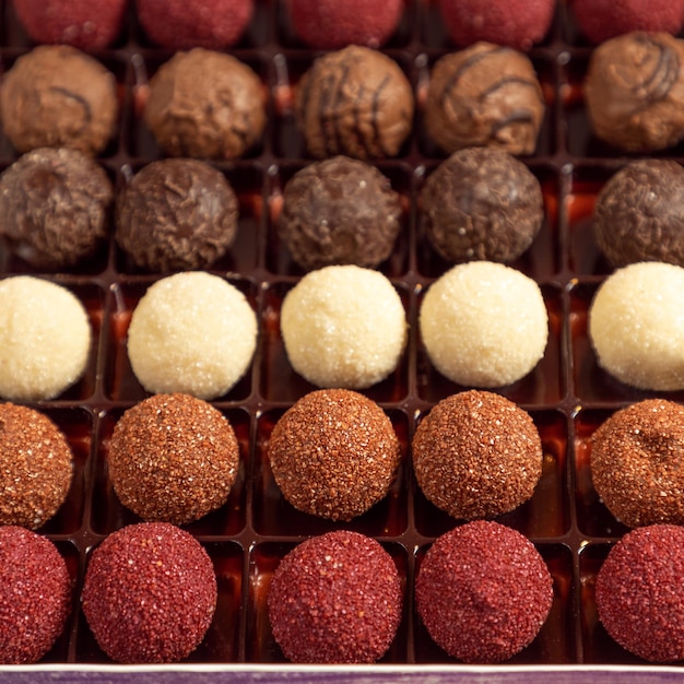 Foto trufas de chocolate de colores con cacao en polvo