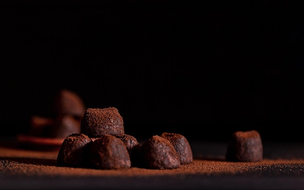 Trufas de chocolate negro en polvo de cacao esparcido