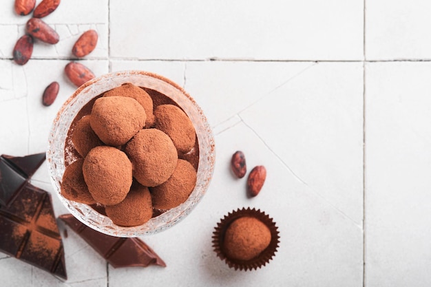 Trufas de chocolate Trufas de chocolate caseras con cacao en polvo sobre vidrio en el fondo de la mesa de baldosas viejas rotas Sabrosas trufas de chocolate dulces dulces Concepto del Día de San Valentín y el Día de la Madre