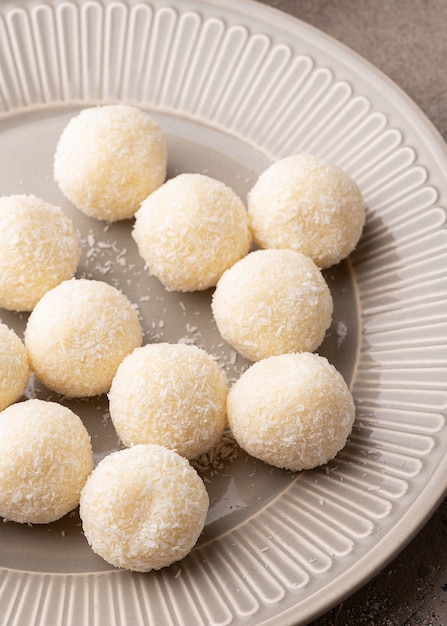 Trufas de chocolate branco caseiro de coco num prato cinzento