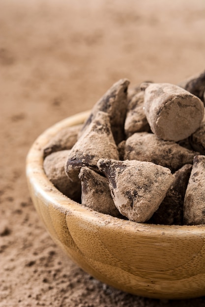 Trufas de chocolate caseiras em uma tigela de madeira na mesa de madeira