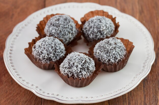 Trufas de chocolate com coco no prato branco