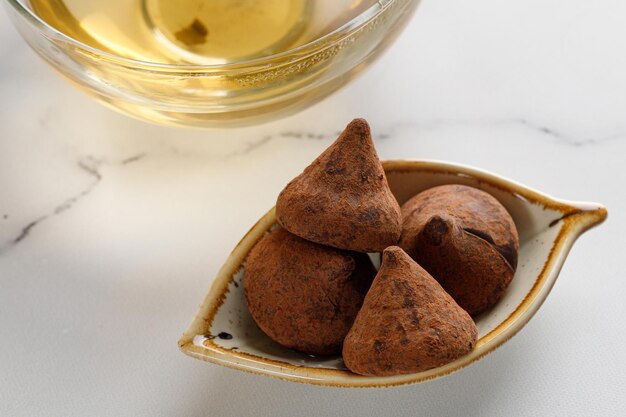 Trufas de doces fecham com copo de vidro ou caneca com chá verde de ervas. minimalismo.