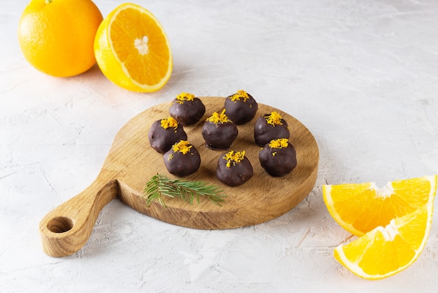 Trufas de laranja em chocolate em uma placa de madeira