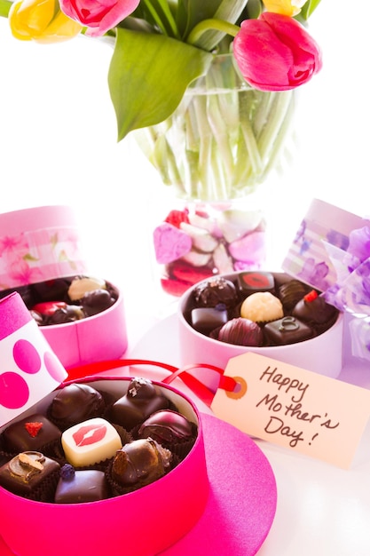 Trufas sortidas em caixas de formato de chapéu fofo para o dia das mães.