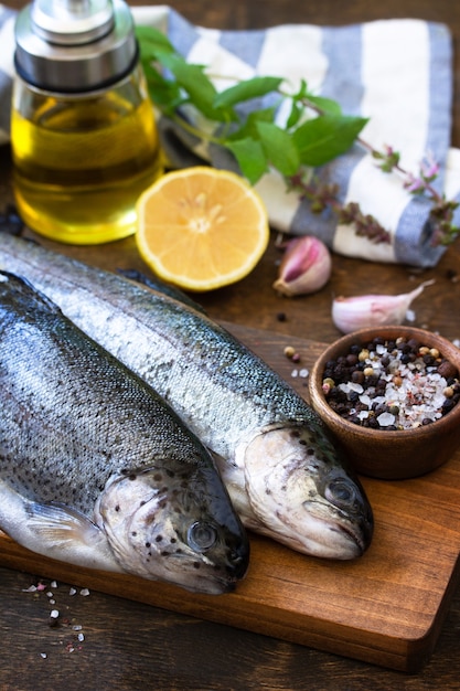 Truta crua fresca e ingredientes em picles em uma mesa de madeira Preparação de peixe grelhado