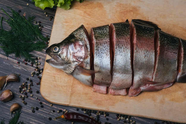 Truta fresca cortada em pedaços em uma placa de madeira, peixe vermelho cru